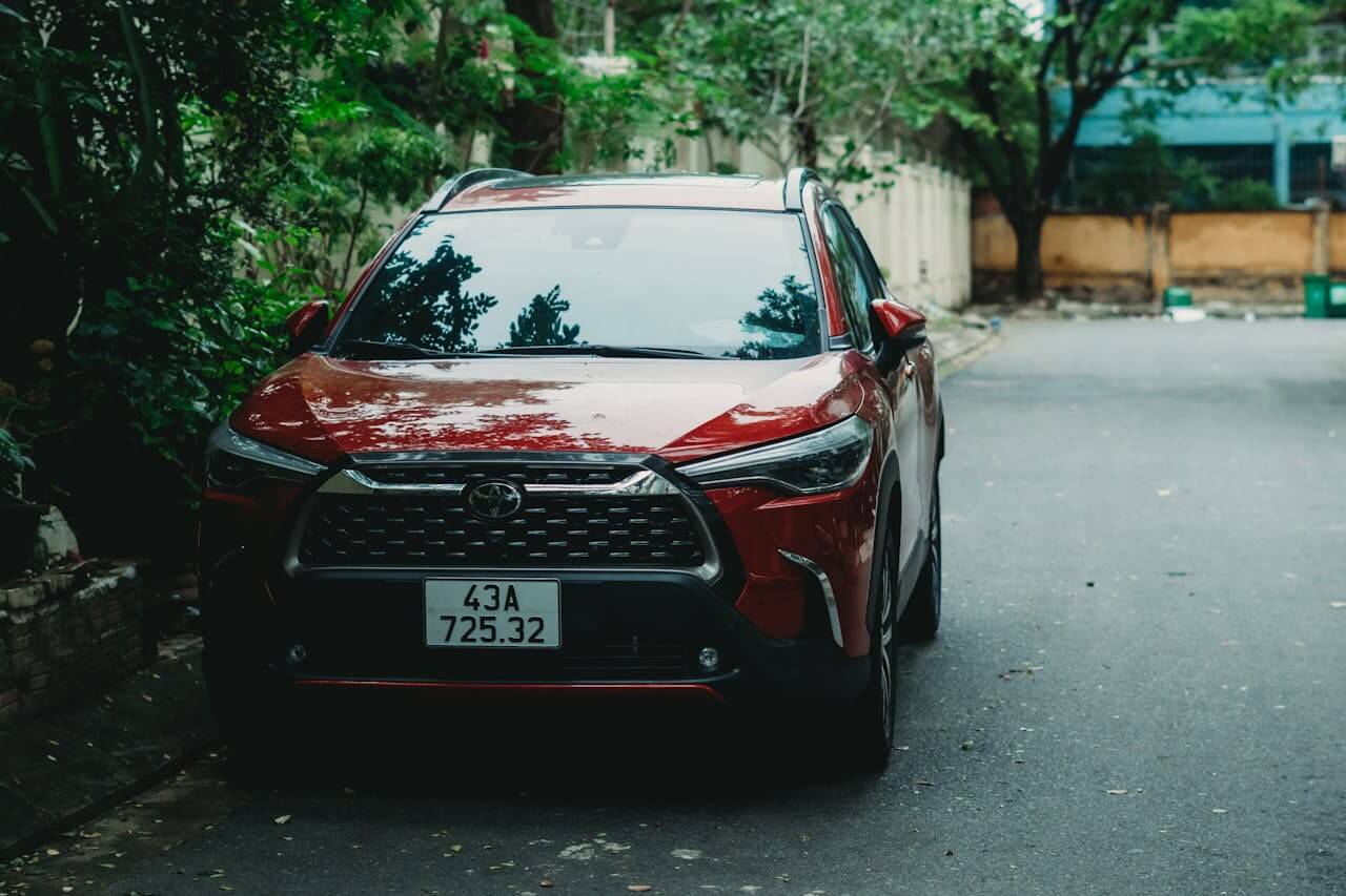 red Toyota Corolla under the trees